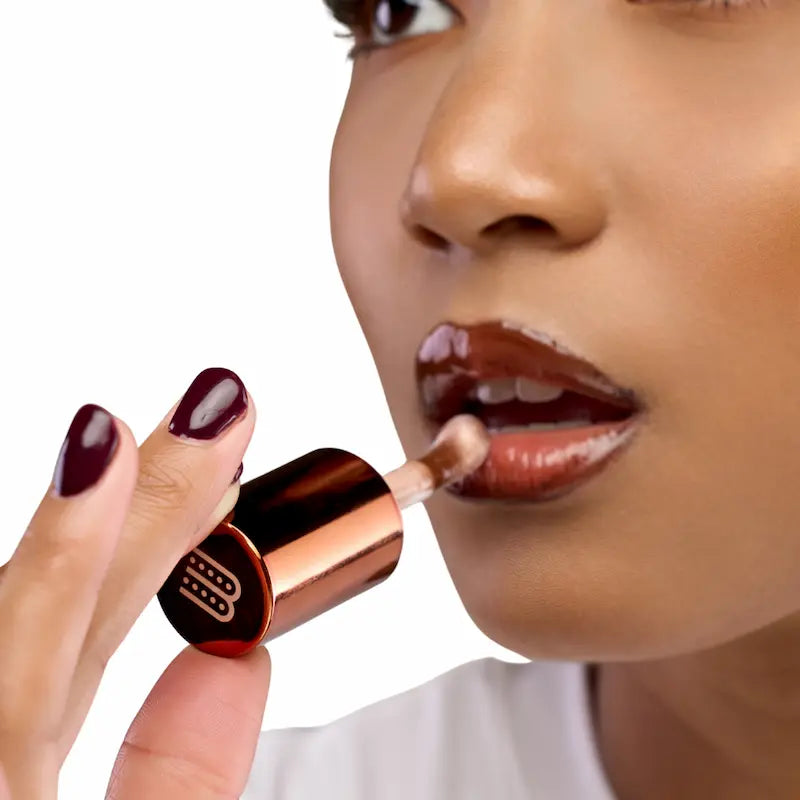 Huile à lèvres teintée Café Touba Wuré utilisée en top coat pour un fini glossy, nourrissant et non collant, idéale pour sublimer un rouge à lèvres tout en hydratant les lèvres.