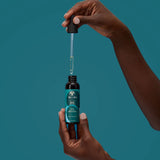 Huile hydratante et fortifiante de As I Am Bond, enrichie en Céramides, Amla et Moringa est formulée pour soigner les cheveux abîmés et secs.