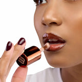Huile à lèvres teintée Café Touba Wuré utilisée en top coat pour un fini glossy, nourrissant et non collant, idéale pour sublimer un rouge à lèvres tout en hydratant les lèvres.